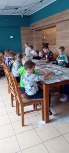 Dzieci siedzące przy stole podczas warsztatów pizzy